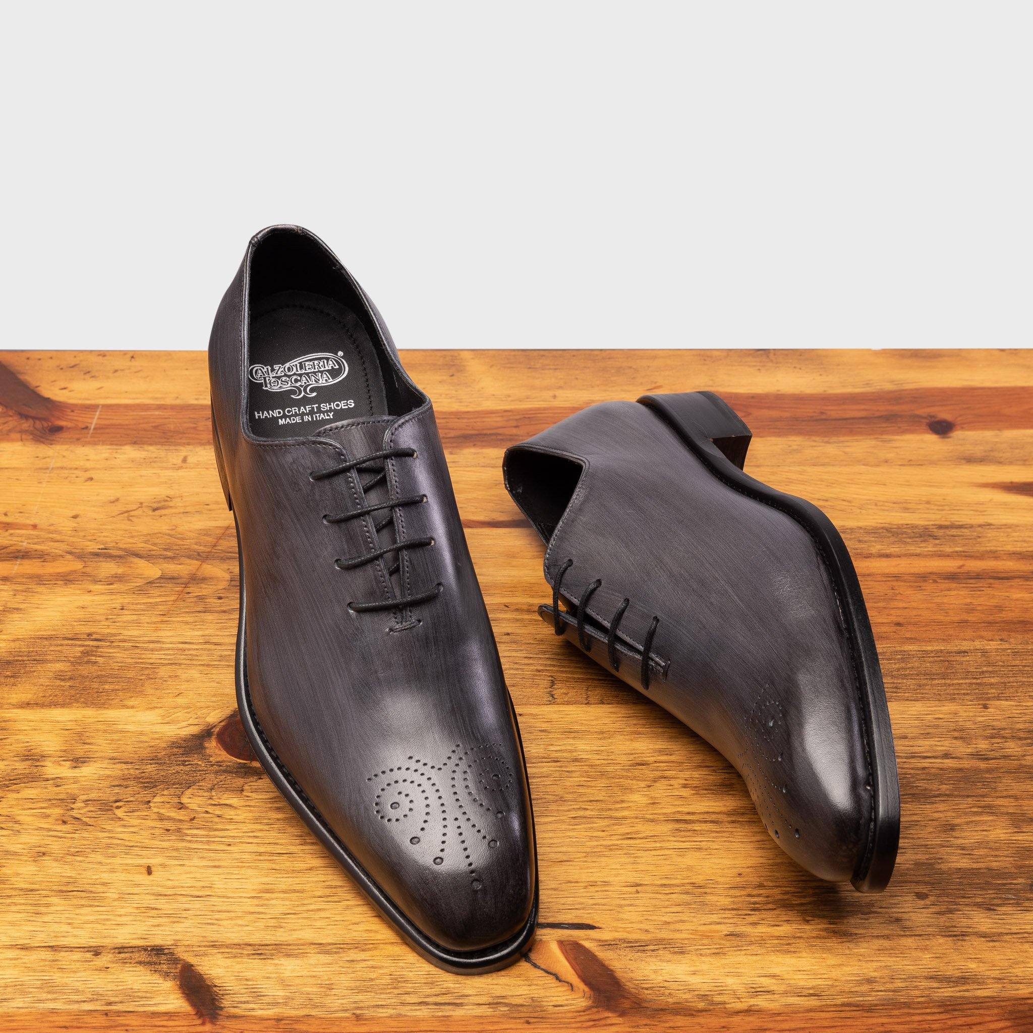 Pair of 4633 Calzoleria Toscana Grey Wholecut Balmoral showing the brand name label of the insole on top of a wooden table